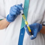 Healthcare professional preparing a stem cell therapy injection in a clinical setting