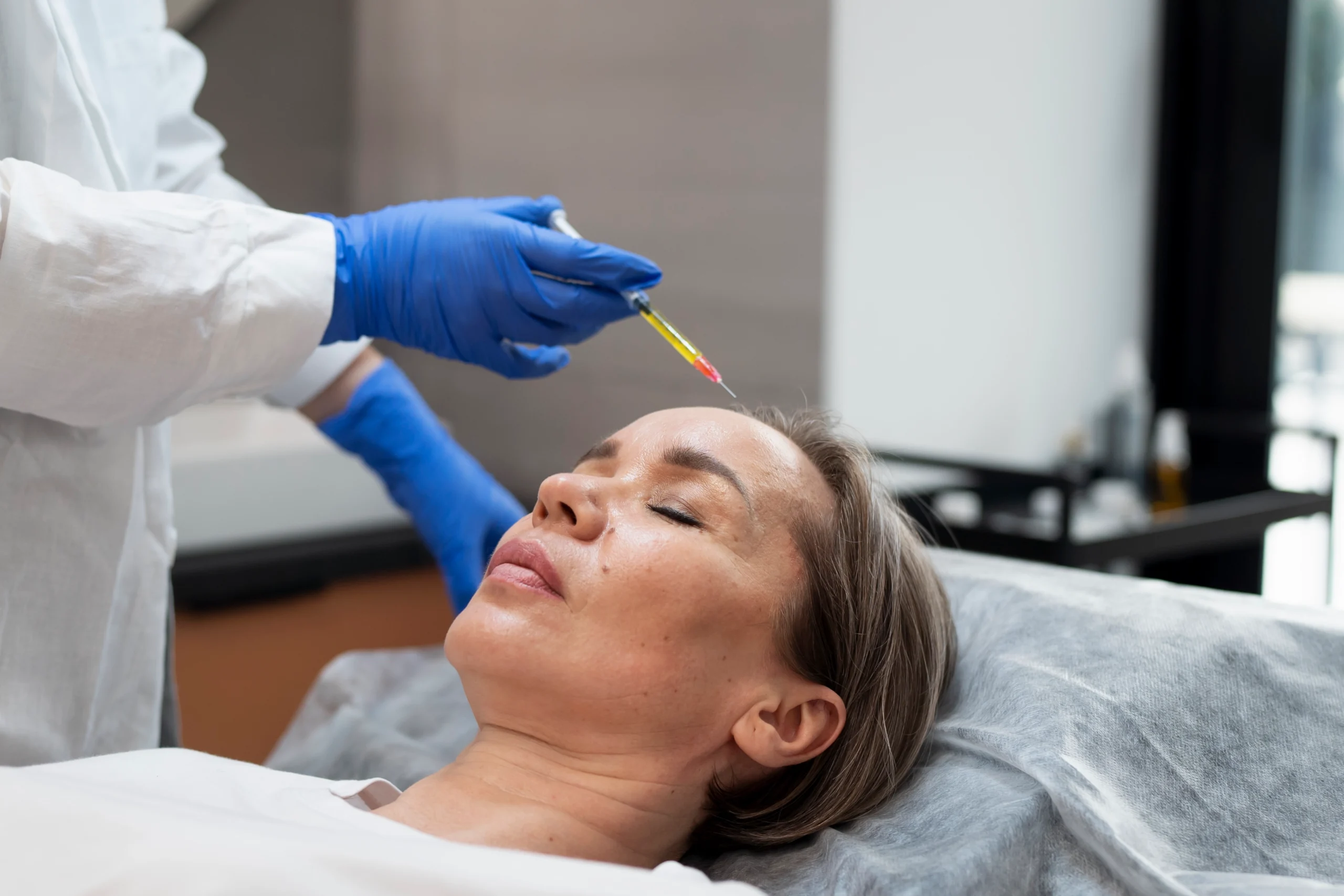 Patient receiving an injection-based treatment in a clinical setting